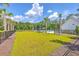 Community pool area surrounded by palm trees, lush lawns, and a black metal fence at 312 Cypress Knee Landing, Summerville, SC 29483