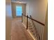 A carpeted hallway leading upstairs with white railings and a window at 317 Whispering Breeze Ln, Summerville, SC 29486