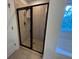 Modern bathroom shower with black frame, neutral tile, and glass door at 317 Whispering Breeze Ln, Summerville, SC 29486