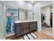 Bright bathroom with double vanity, decorative shelves, and a walk-in closet at 324 Spruce Ivy St, Moncks Corner, SC 29461