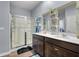 Bright bathroom with double vanity, decorative shelves, and a glass-enclosed shower at 324 Spruce Ivy St, Moncks Corner, SC 29461
