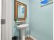 Charming powder room with a pedestal sink, stylish mirror, and calming blue walls, creating a serene ambiance at 324 Spruce Ivy St, Moncks Corner, SC 29461