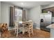 Cozy dining area with natural light from window, table and chairs, and stainless steel refrigerator at 324 Spruce Ivy St, Moncks Corner, SC 29461