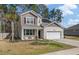 Inviting two-story home with a manicured front yard, a two-car garage, and energy-saving solar panels at 324 Spruce Ivy St, Moncks Corner, SC 29461