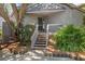Home entrance with a quaint porch and wooden stairs, framed by mature trees and landscaping at 341 Seabrook Island Rd, Seabrook Island, SC 29455
