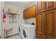Well-lit laundry room featuring a washer, dryer, storage cabinets, and a decorative shelf at 341 Seabrook Island Rd, Seabrook Island, SC 29455