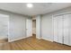 Bedroom with neutral walls, wood floors, a double closet with louvered doors, and access to a bathroom and walk-in closet at 400 Tammie Ave, Goose Creek, SC 29445