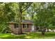 Attractive brick home nestled among mature trees, with a well-manicured lawn, black shutters, and a welcoming light blue front door at 400 Tammie Ave, Goose Creek, SC 29445