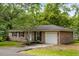 Charming brick home with a well-maintained lawn, mature trees, black shutters, and an attached one-car garage at 400 Tammie Ave, Goose Creek, SC 29445