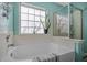 Bright bathroom featuring a garden tub with tiled enclosure, silver fixtures, window, and houseplant for a relaxing atmosphere at 406 Brookfield Ln, Goose Creek, SC 29445