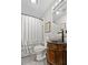 Bathroom with white shower curtain with ruffle, tile flooring and dark wood vanity at 416 Altman St, Moncks Corner, SC 29461