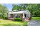 Inviting brick home with a metal roof, rocking chair front porch, and green lawn at 416 Altman St, Moncks Corner, SC 29461