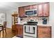 Updated kitchen featuring stainless steel stove, microwave, and brown cabinetry provides a stylish cooking experience at 416 Altman St, Moncks Corner, SC 29461