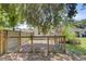 Fenced-in backyard with a sunny lawn, surrounded by mature trees, and various other structures at 422 Geddes Ave, Charleston, SC 29407