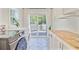 Practical laundry room featuring modern appliances, stylish tile flooring, and backyard access at 422 Geddes Ave, Charleston, SC 29407