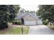 Home's facade highlighting its stone accent, three-car garage, and landscaped front yard at 4969 Franconia Dr, Summerville, SC 29485