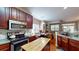 A modern kitchen with wood cabinets, stainless steel appliances, and a granite countertop island at 4969 Franconia Dr, Summerville, SC 29485