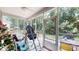 View of the screened-in porch with outdoor seating and a view of the wooded backyard at 4969 Franconia Dr, Summerville, SC 29485