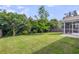 Well-maintained backyard featuring lush green grass, mature trees, a patio, and a screened-in porch for outdoor living at 519 Tarleton Dr, Summerville, SC 29483