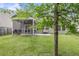 Backyard featuring a screened porch, a concrete patio with seating, a grassy lawn, and a tree in the foreground at 519 Tarleton Dr, Summerville, SC 29483