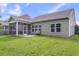 Backyard with a screened porch, concrete patio with seating, green lawn and the back of the house at 519 Tarleton Dr, Summerville, SC 29483