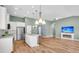Open concept living room with fireplace, wood floors, ceiling fan, and kitchen area with an island at 519 Tarleton Dr, Summerville, SC 29483