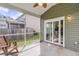 Covered, screened porch with a ceiling fan, concrete flooring, wooden rocking chairs, and sliding glass doors at 519 Tarleton Dr, Summerville, SC 29483