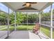 A screened porch with white trim, a ceiling fan, concrete flooring, and a wooden rocking chair at 519 Tarleton Dr, Summerville, SC 29483