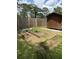 Green backyard with a wooden privacy fence, wooden shed, and multiple garden boxes at 702 N N Palmetto St, Summerville, SC 29483