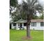 Well-maintained home featuring white brick, black trim, a green lawn, and mature landscaping at 702 N N Palmetto St, Summerville, SC 29483