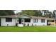 Charming one-story home with white brick exterior, well-manicured lawn, and covered carport at 702 N N Palmetto St, Summerville, SC 29483