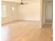 Open living room featuring wood-look floors, neutral walls, a ceiling fan, and access to hallway at 702 N N Palmetto St, Summerville, SC 29483