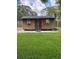 Backyard shed with a double door, windows, dark siding, and a green lawn at 702 N N Palmetto St, Summerville, SC 29483