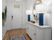 Bright entryway has white paneled walls, a console table with blue lamps, and wood flooring at 727 Breakers Reef Ln, Huger, SC 29450