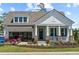 Charming two-story home boasts a manicured lawn, inviting porch, and modern garage at 727 Breakers Reef Ln, Huger, SC 29450