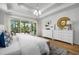 Serene main bedroom with natural light, a decorative mirror, and wood floors at 727 Breakers Reef Ln, Huger, SC 29450