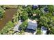 Aerial view of a home with dark roof near a tranquil pond, surrounded by lush greenery at 817 Cheehaw St, Edisto Island, SC 29438