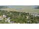 A detailed aerial view highlights the property's location within lush greenery, near a waterway and charming neighborhood at 817 Cheehaw St, Edisto Island, SC 29438