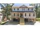 New two-story home featuring a charming porch and stairs leading to the main entrance, surrounded by lush trees at 817 Cheehaw St, Edisto Island, SC 29438