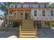 New construction of a coastal home with a spacious front porch and wooden staircase at 817 Cheehaw St, Edisto Island, SC 29438