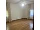 Empty bedroom with hardwood floors, ceiling fan, and natural light from the windows with floral curtains at 874 Evans Rd, Charleston, SC 29412