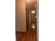 Hallway with wood flooring leading to an open doorway with light coming through and paneled doors to the side at 874 Evans Rd, Charleston, SC 29412