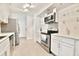 Modern kitchen featuring stainless steel appliances, white cabinetry, marble countertops, and stylish tile flooring at 93 Ashley Hall Plantation Rd # 6, Charleston, SC 29407