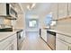 Modern kitchen featuring stainless steel appliances, white cabinets, marble countertops, and tile flooring with an open layout at 93 Ashley Hall Plantation Rd # 6, Charleston, SC 29407
