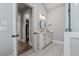 Bathroom featuring a white marble shower, vanity with a round mirror, and walk-in closet at 1052 Avenue Of Oaks, Charleston, SC 29407