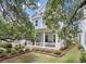 Charming blue two-story home featuring a cozy front porch and beautifully landscaped yard at 1052 Avenue Of Oaks, Charleston, SC 29407