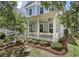Inviting two-story home with a welcoming front porch and lush landscaping at 1052 Avenue Of Oaks, Charleston, SC 29407