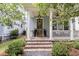 Inviting front porch with brick steps, white columns, and a craftsman style front door at 1052 Avenue Of Oaks, Charleston, SC 29407