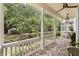 Covered front porch showcasing brick flooring, classic white columns, and peaceful neighborhood views at 1052 Avenue Of Oaks, Charleston, SC 29407