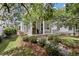 Beautifully landscaped yard with a craftsman-style home featuring a welcoming front porch with white columns at 1052 Avenue Of Oaks, Charleston, SC 29407